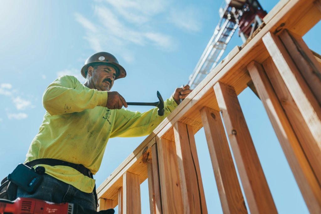 Building in the Township of Nipissing: A man constructs wooden framing for a building.